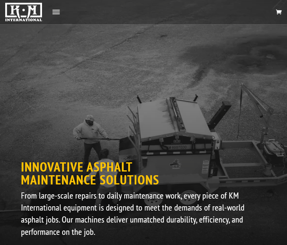KM International website banner showing an overhead view of a worker operating asphalt maintenance equipment, with the headline “Innovative Asphalt Maintenance Solutions.”