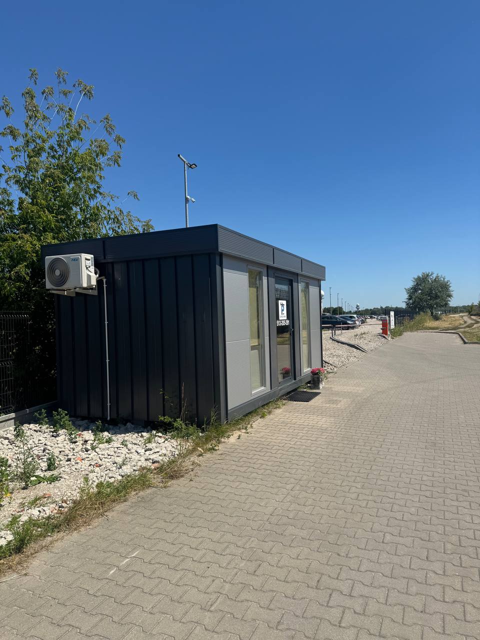 A small black building sitting on the side of a road.