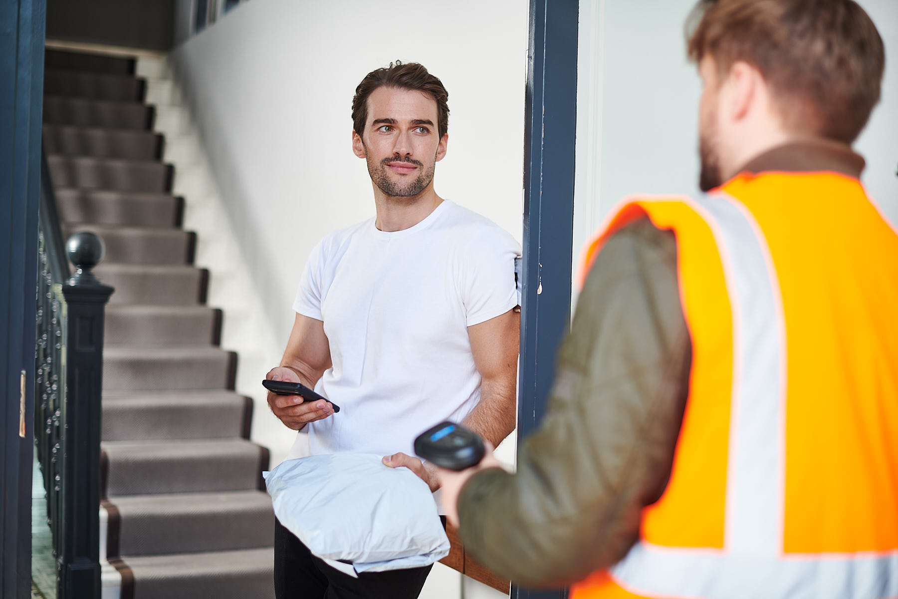 A customer handing their return to a delivery driver