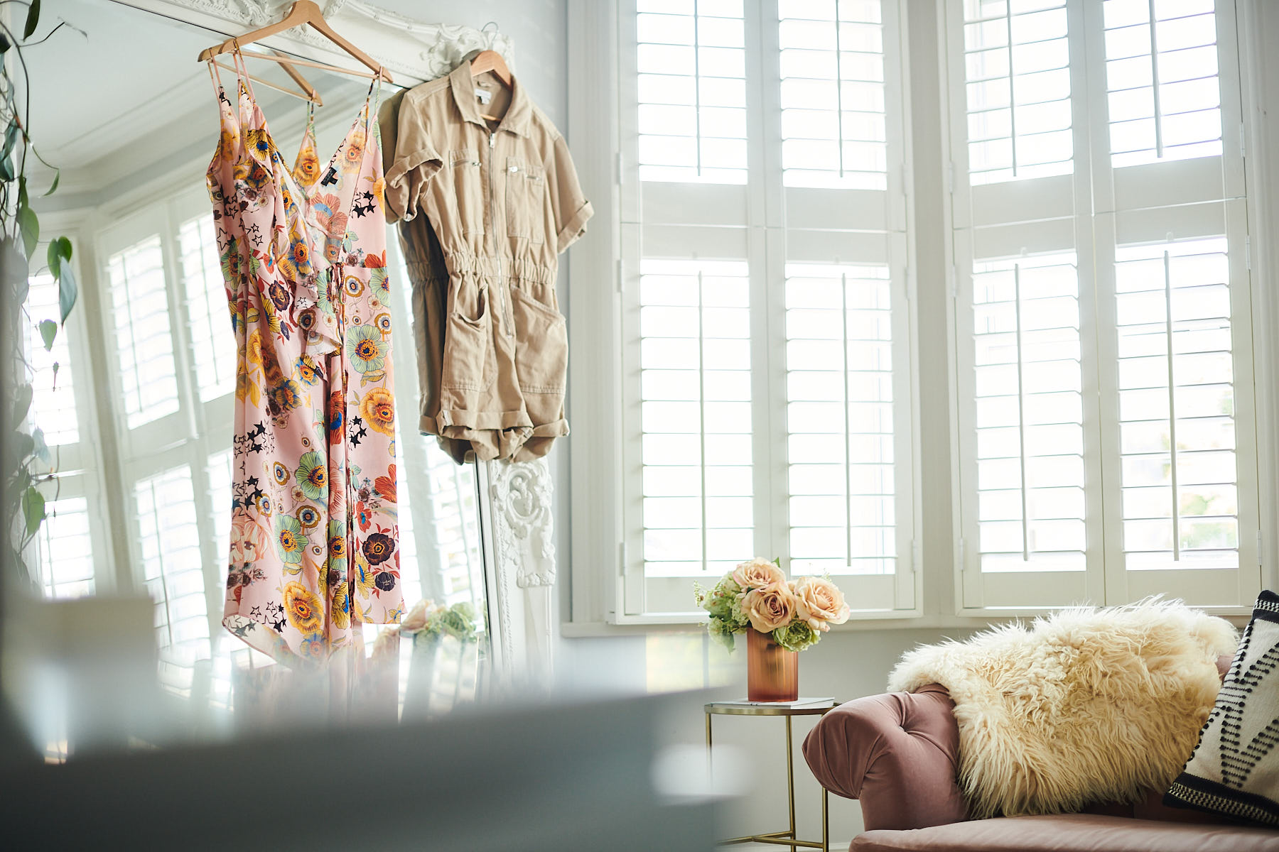 Clothes hanging on a mirror in a bedroom
