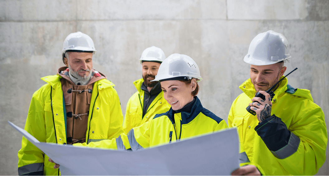 Teambild von vier Personen in Baukleidung
