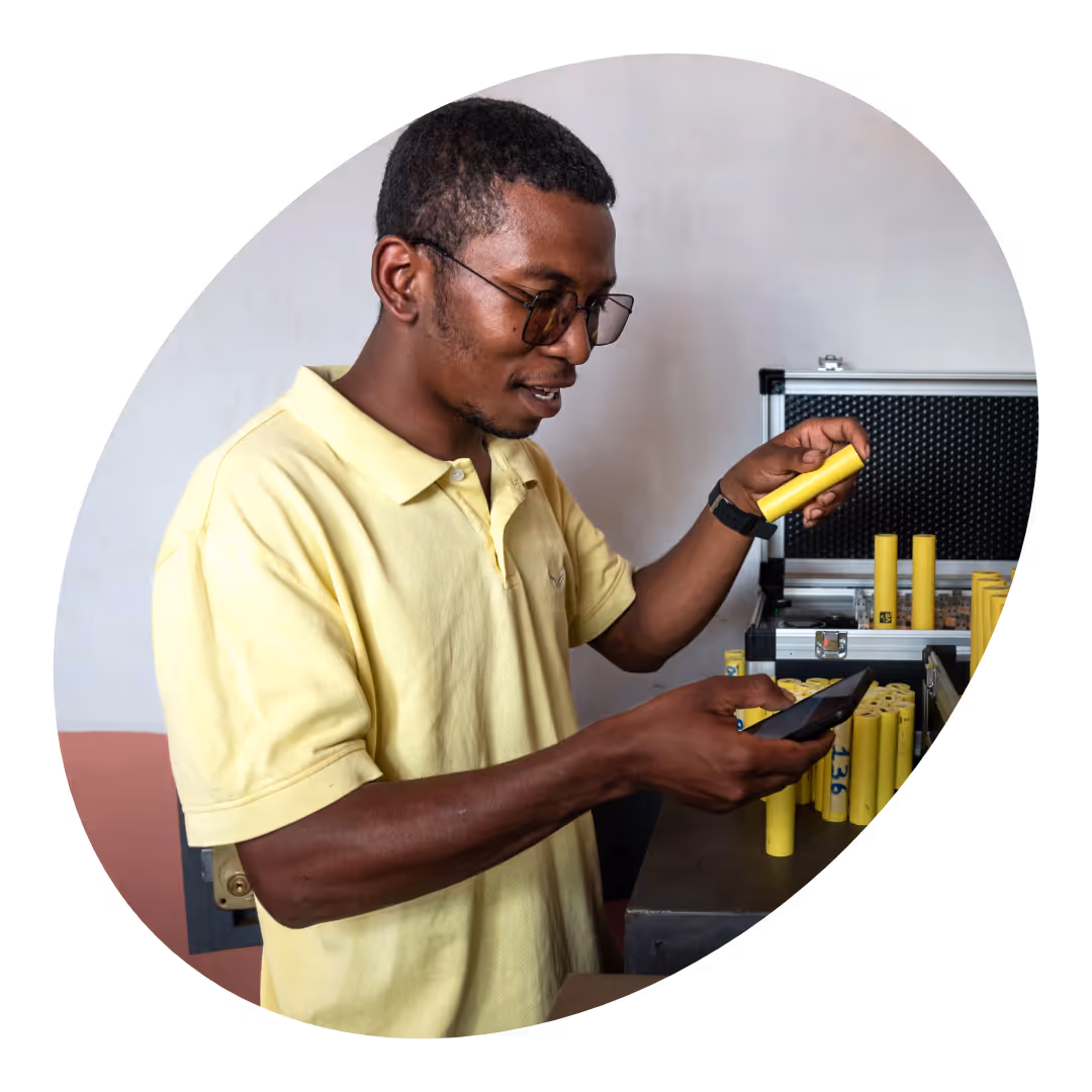 A man standing in front of a box with yellow solar batteries.