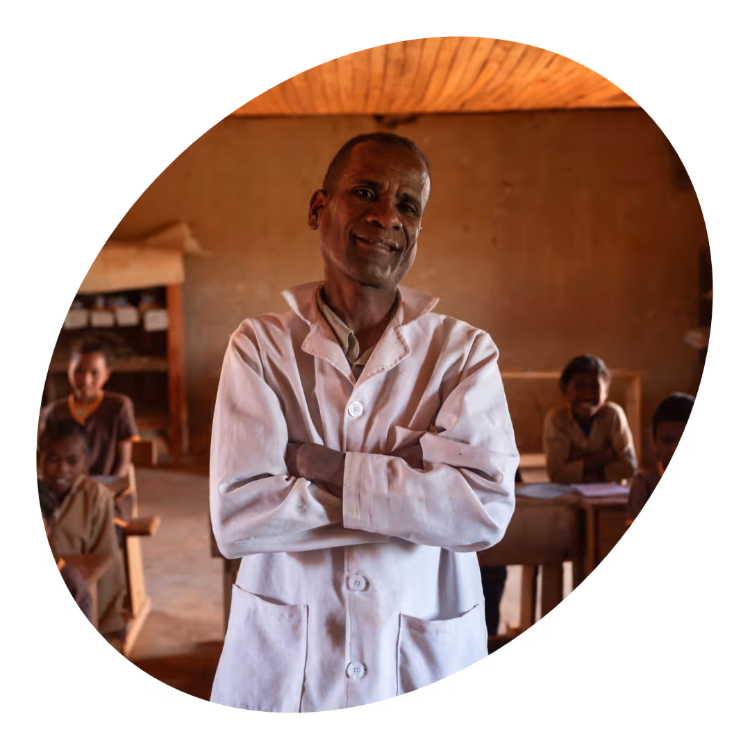 A teacher in a classroom posing for a photo.  