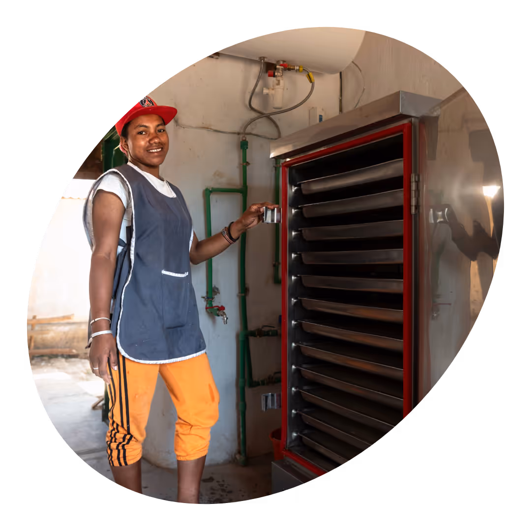 A woman standing next to solar cooker.