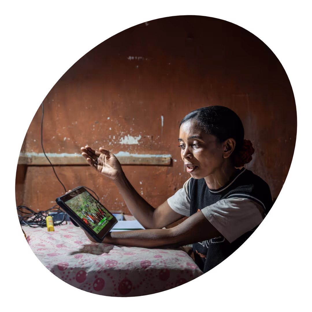 A woman sitting at the table and holding a tablet.