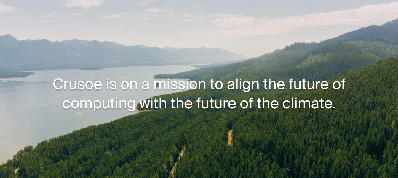Aerial view of dense evergreen forest beside a calm lakelaid with the text: ‘Crusoe is on a mission to align the future of computing with the future of climate.