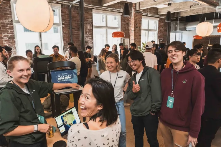A photo showing a people smiling at a Crusoe networking event.