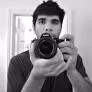 Professional photo of Prasanth Veerina (Co-founder of Pixelcut) in a dark T-shirt taking a self-portrait with a DSLR camera.