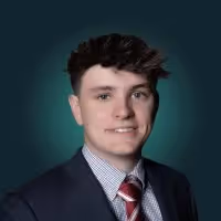 Headshot of Grant Jensen against dark background.