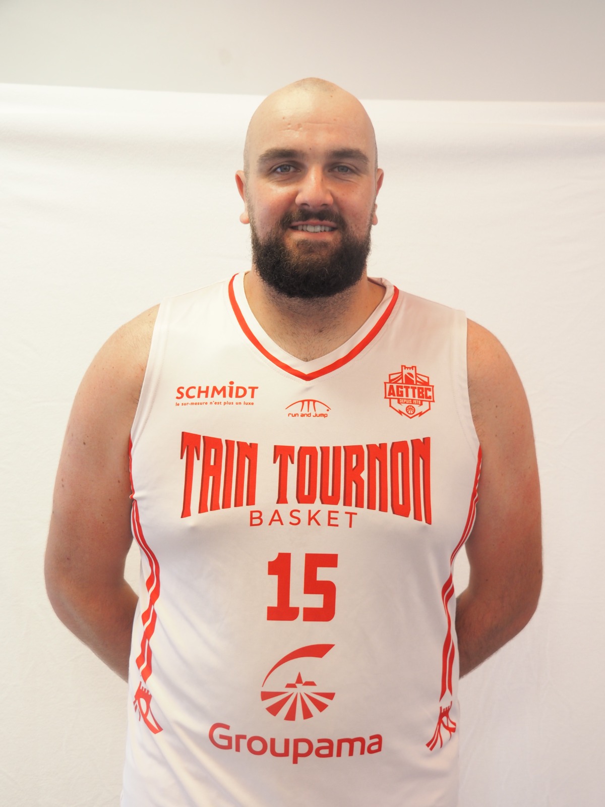 Joueur de basket portant le maillot blanc numéro 15 de Tain Tournon Basket avec logos rouges.