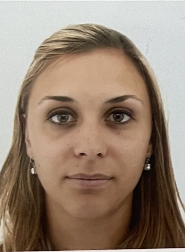 Portrait d'une femme aux cheveux longs blonds, regardant l'appareil avec un fond clair.