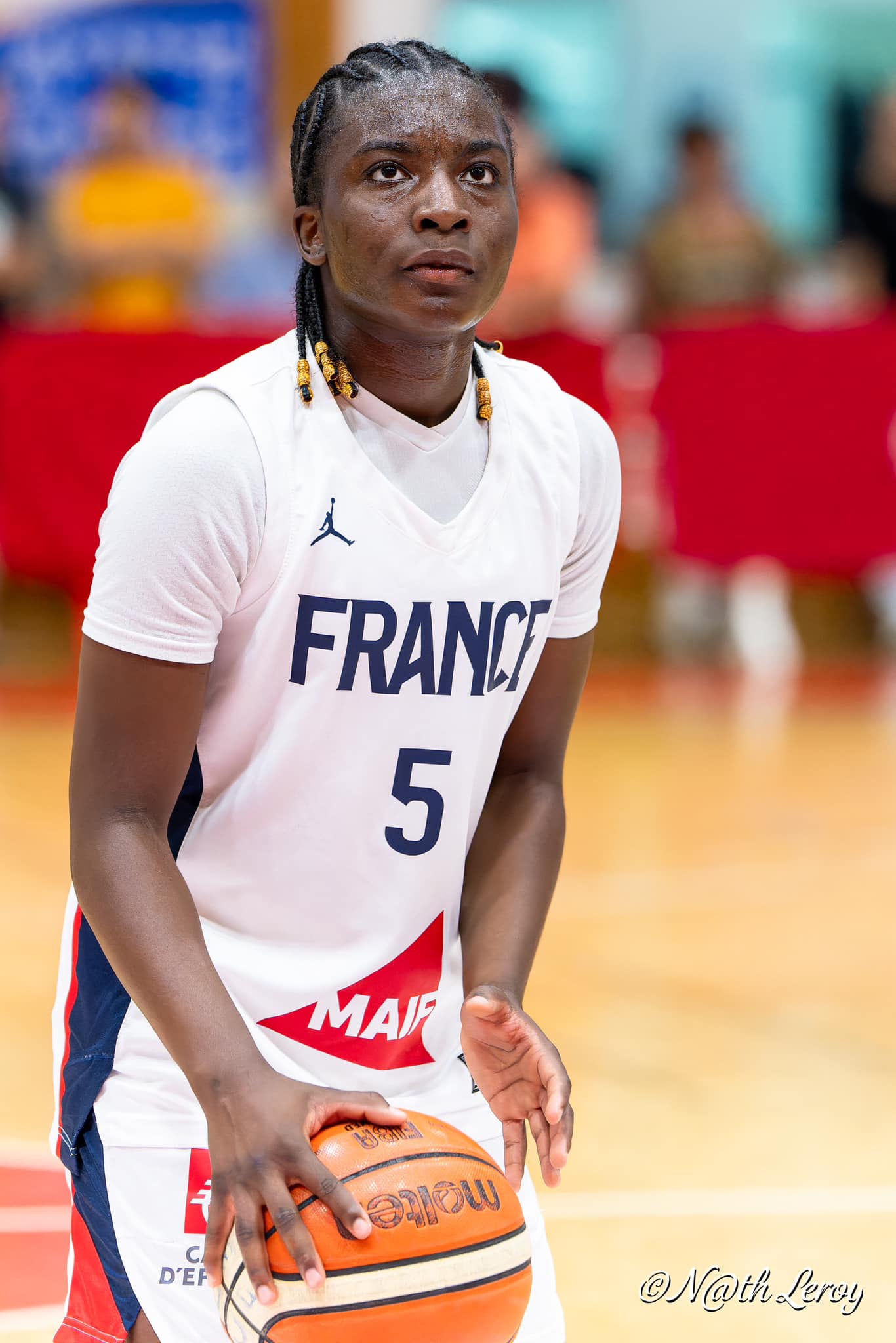 Joueuse de basketball de l'équipe de France portant le numéro 5, en train de dribbler.