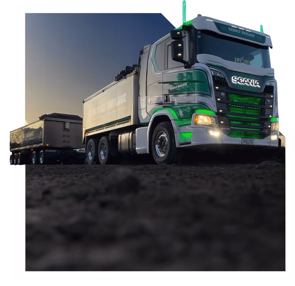 Scania truck with green accents, hauling cargo on a dirt road outdoors.