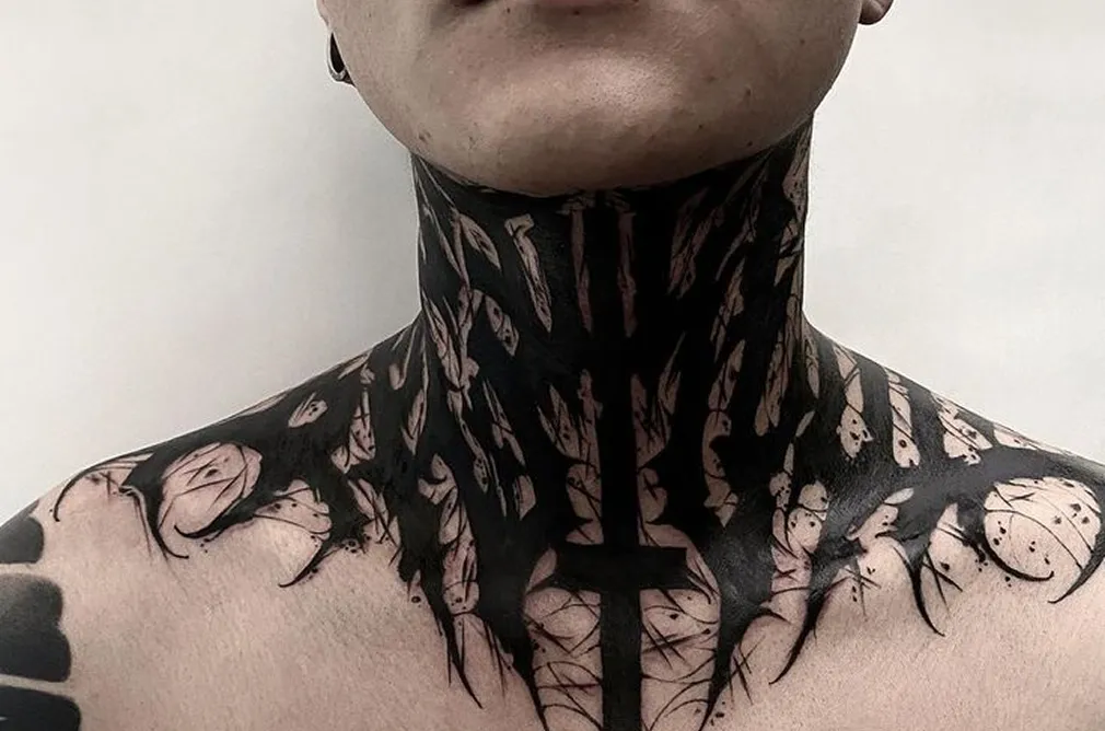 Intricate black and grey tattoo of a geometric design with broken elements on the neck and chest, creating a dramatic effect.
