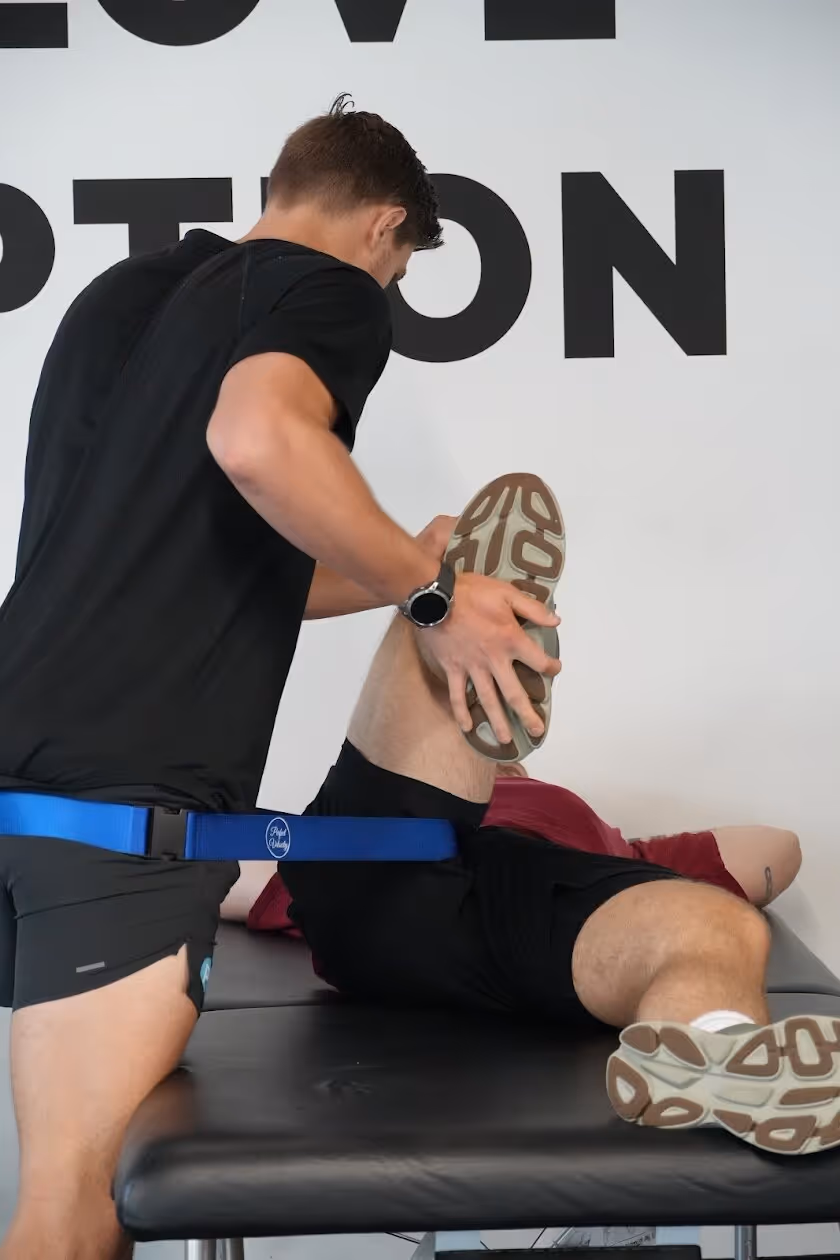 Physical therapist helping Philadelphia athlete rehabilitate knee injury with strength training