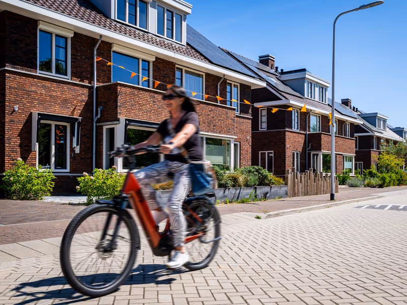 Vrouw op fiets in wijk
