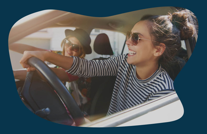 two young female friends driving a carsharing vehicle for the first time