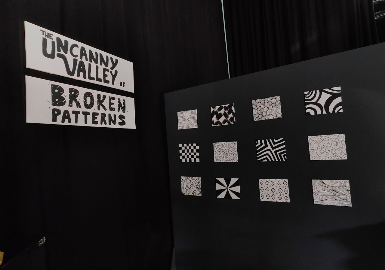 Exhibit titled 'The Uncanny Valley of Broken Patterns' with twelve black-and-white abstract pattern designs displayed on a dark wall.