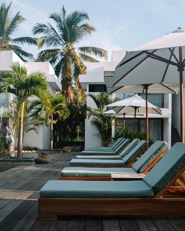A row of lounge chairs sitting on top of a wooden deck.