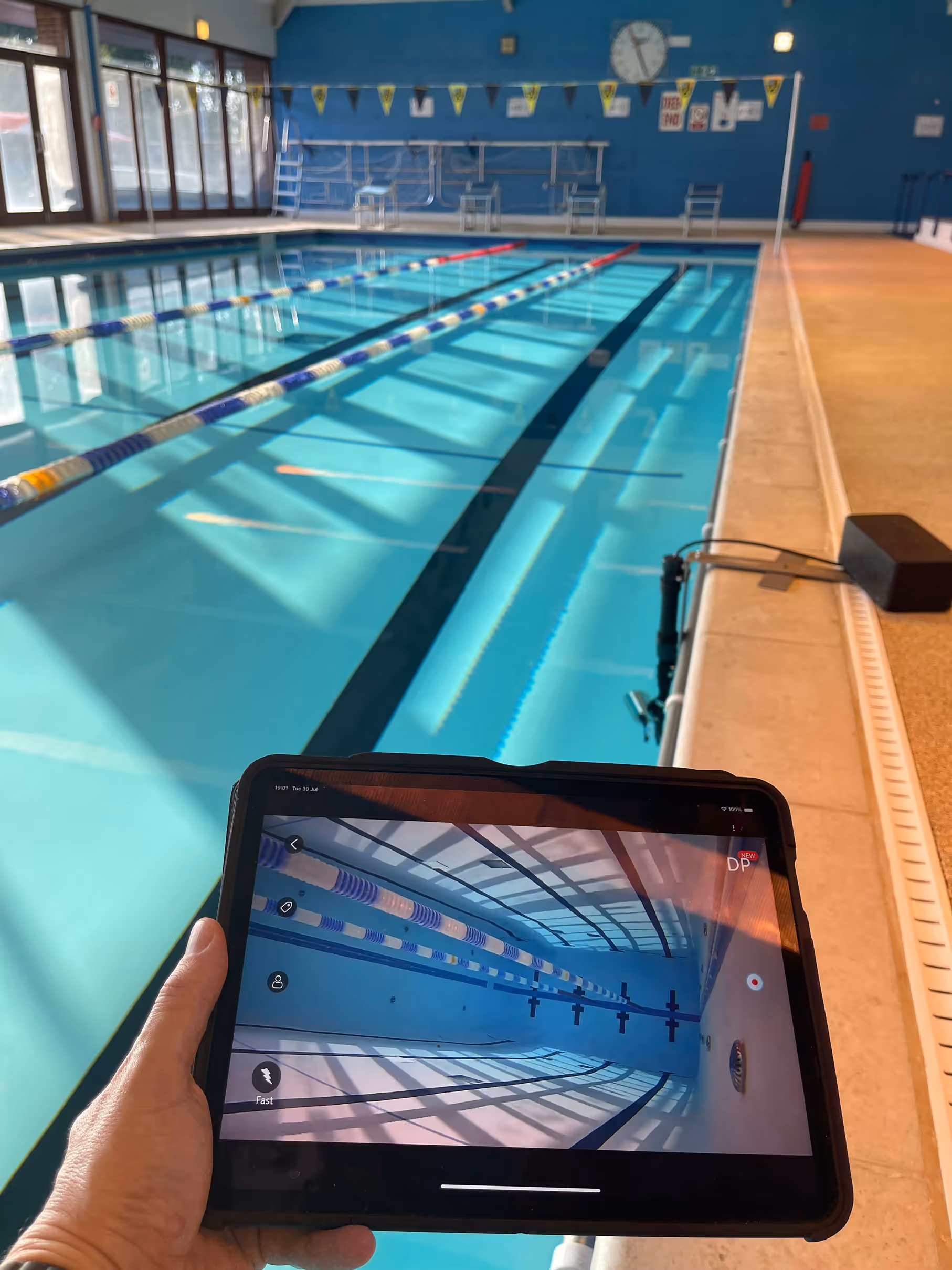 Smart tablet being held by a swimming pool