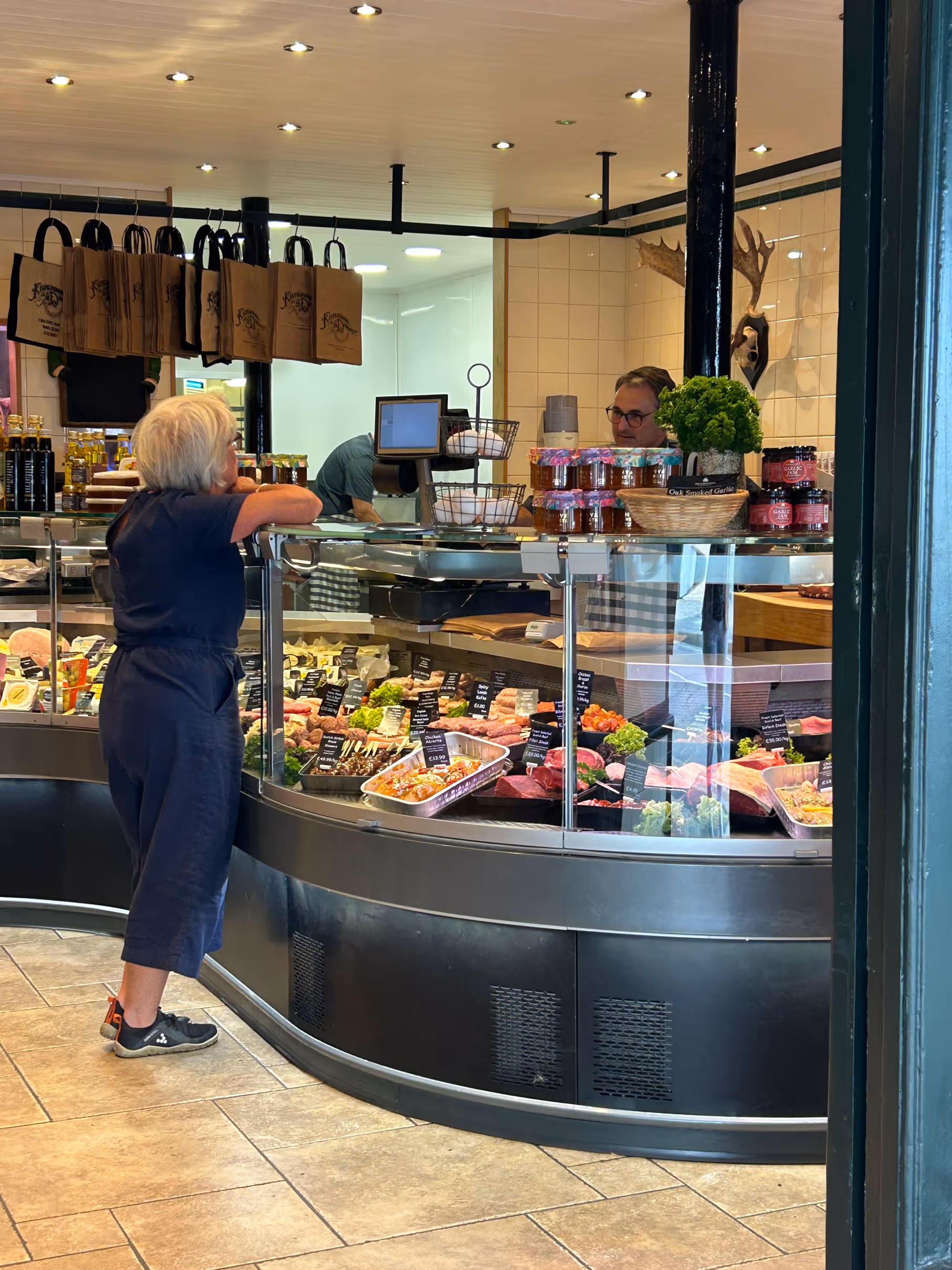 Woman standing at a counter in a butcher shop