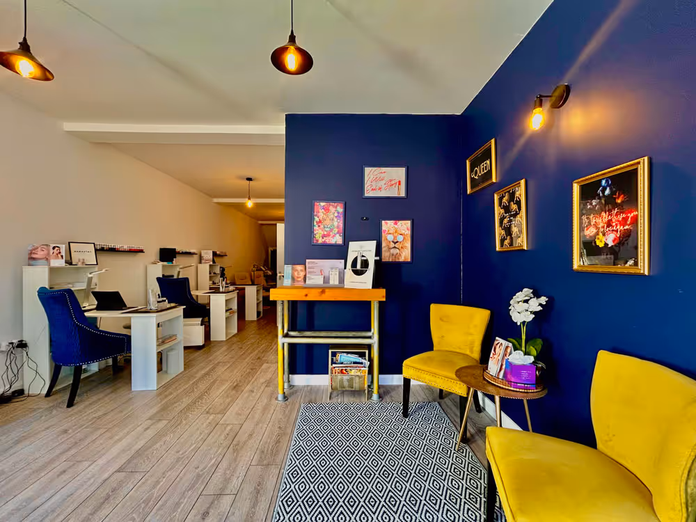Yellow fabric chairs in a blue room with paintings on the wall
