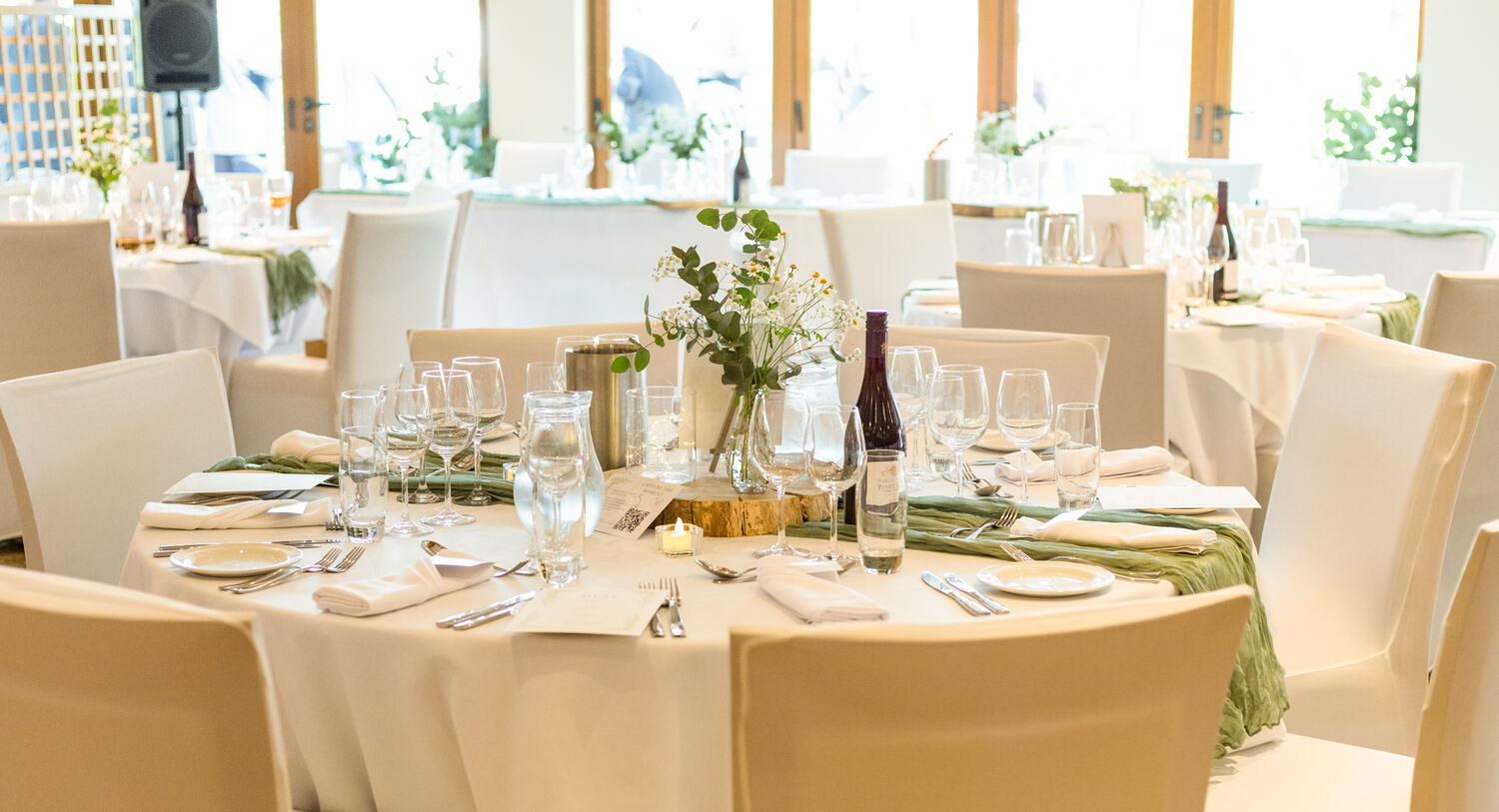 Tables dressed for a wedding with cream and white decorations