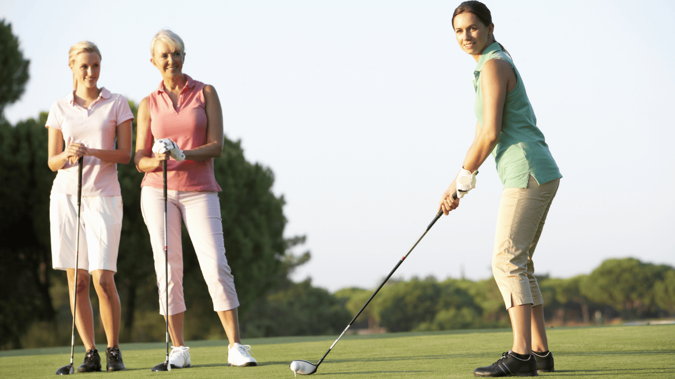 Three women playing golf in the afternoon sun