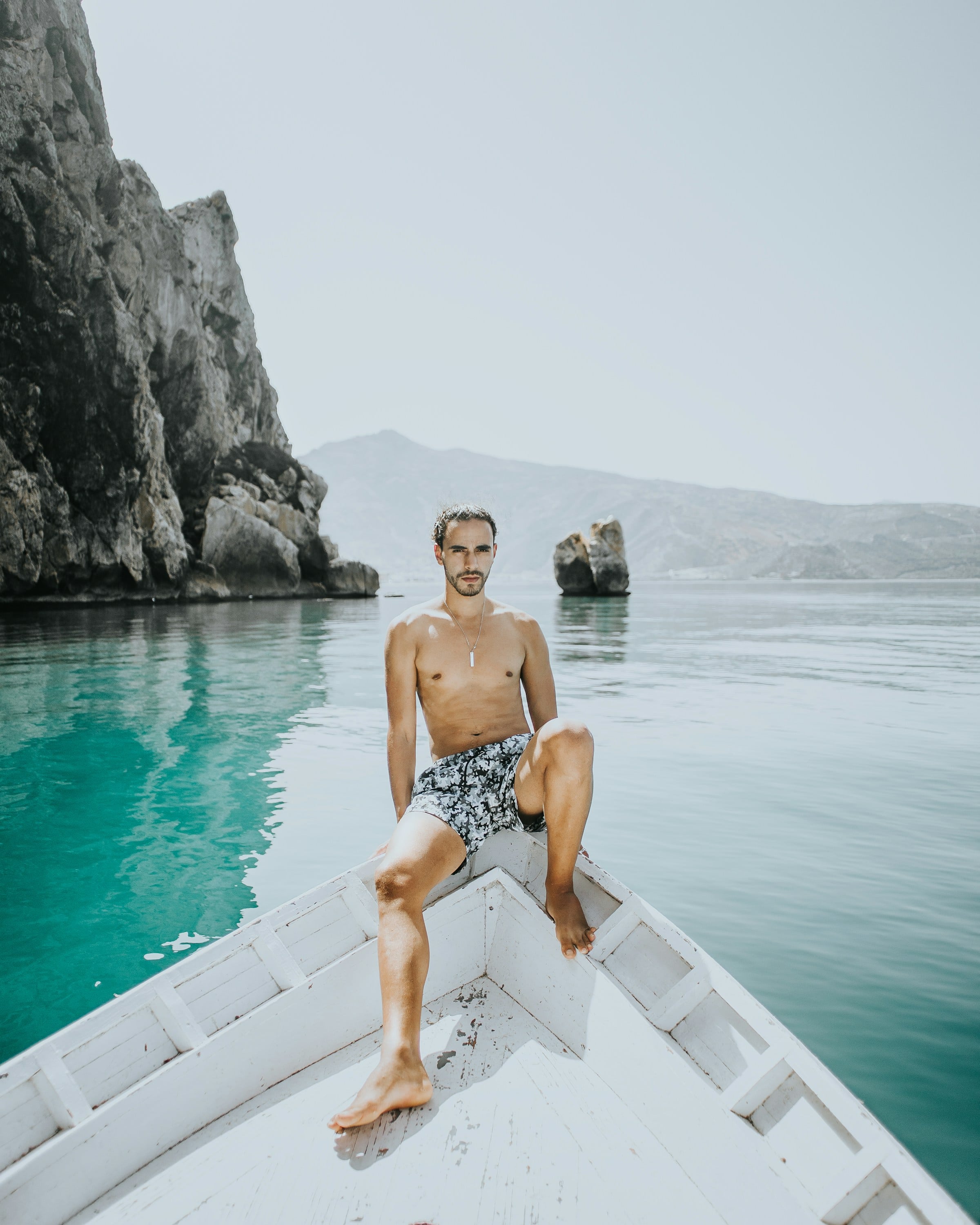 A man sits on a boat while on holiday looking into the camera