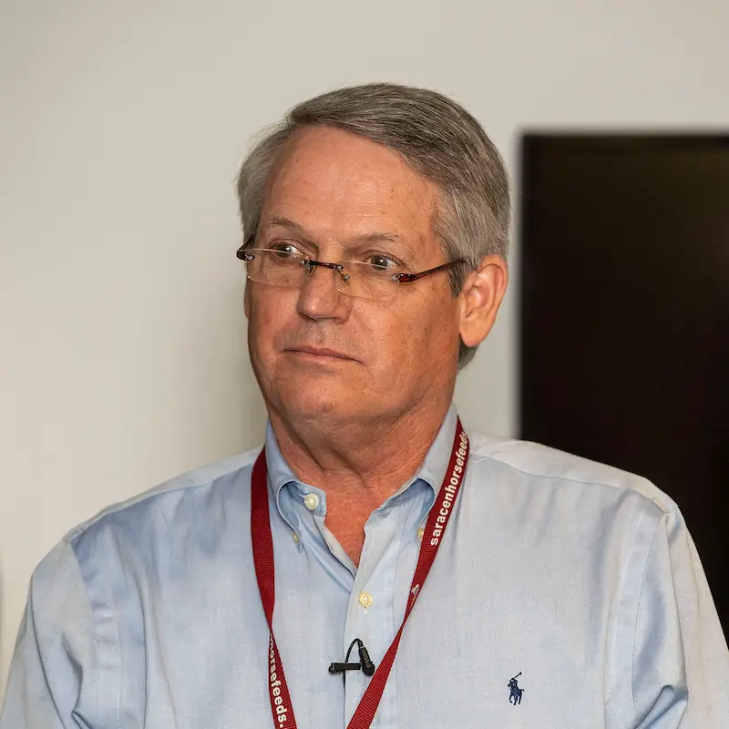 Middle-aged man with glasses wearing a light blue shirt and red lanyard looking slightly to the side.
