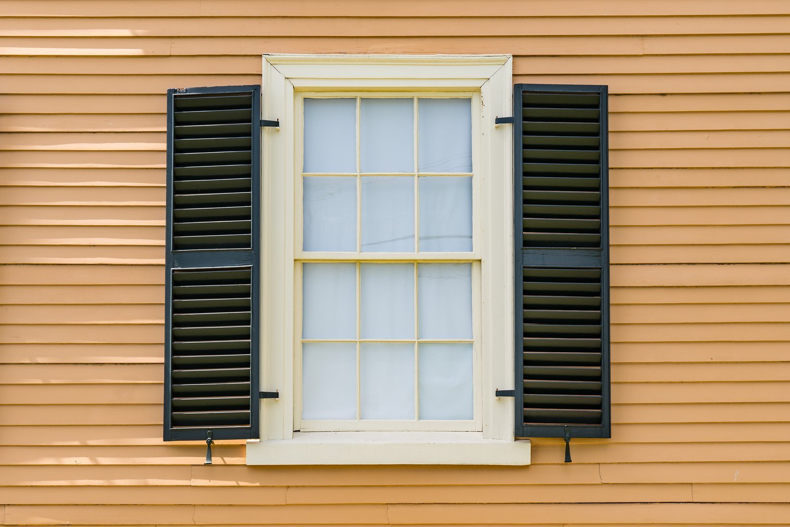 Double-hun window on house with yellow siding