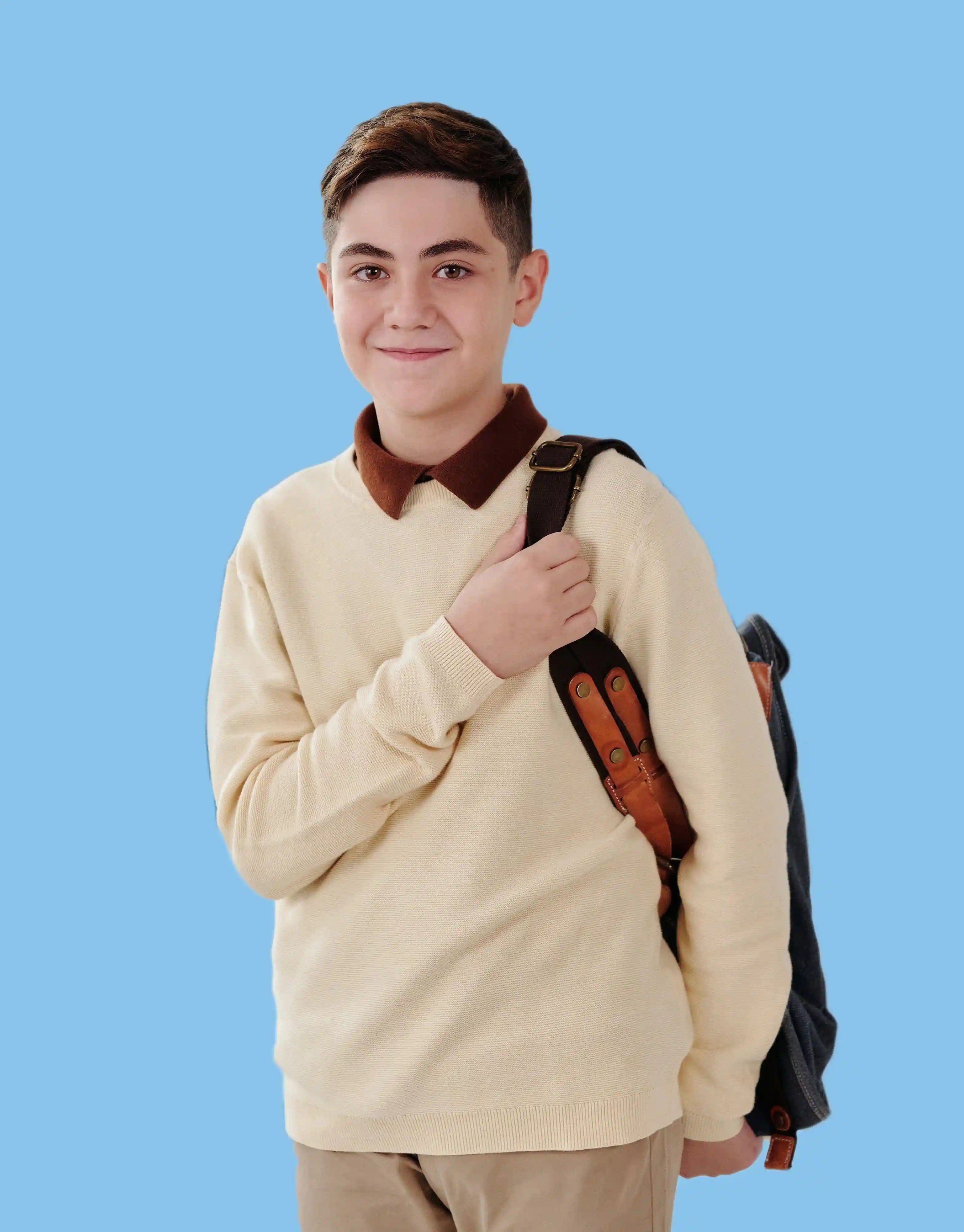 Boy with backpack on blue background
