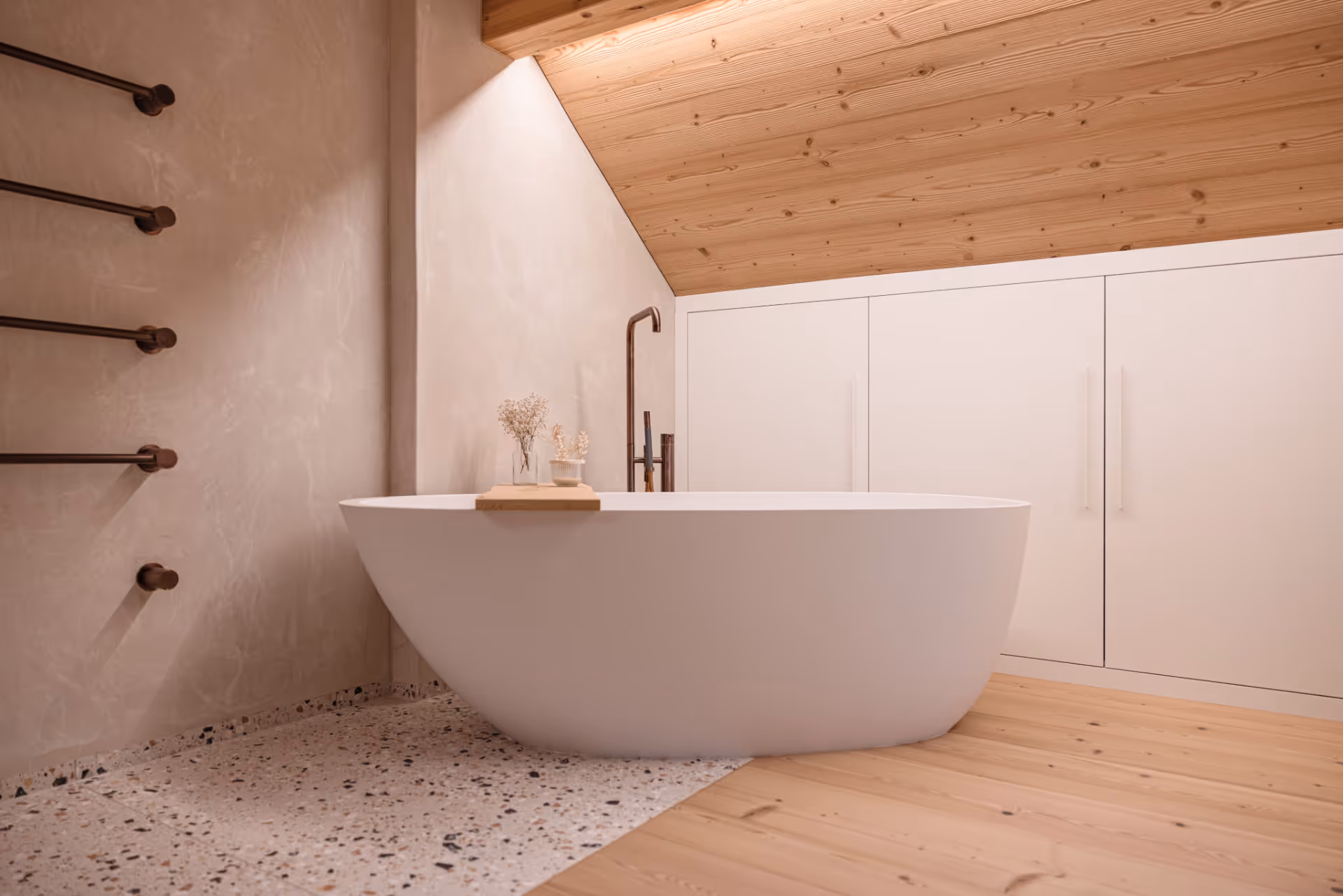 Freistehende, ovale weisse Badewanne in einem modernen Badezimmer mit Dachschräge, Holzboden und weissen Einbauschränken.