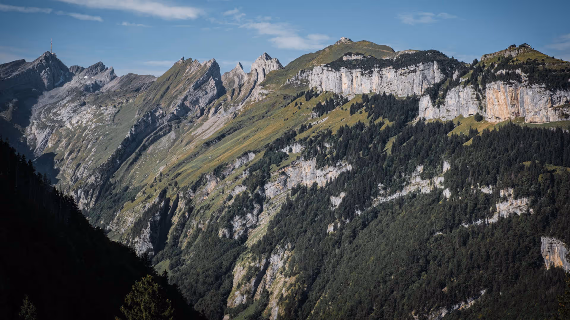 Foto vum Hutter. Beeindruckendes Panorama des Alpstein-Massivs in der Schweiz mit steilen Felswänden, grünen Hängen und Wäldern.