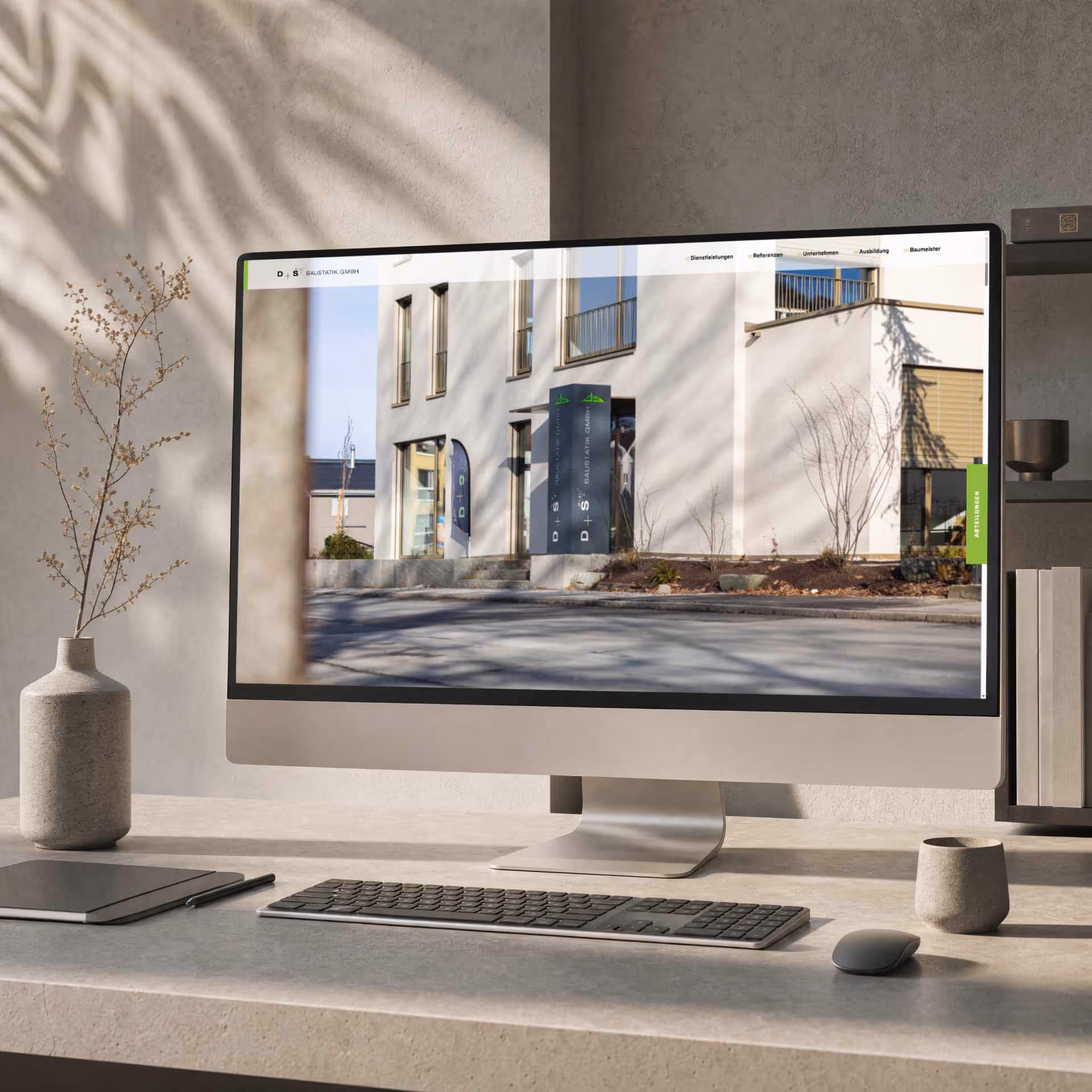 Monitor mit der Website-Startseite der D+S Baustatistik GmbH in einer modernen Büroumgebung.