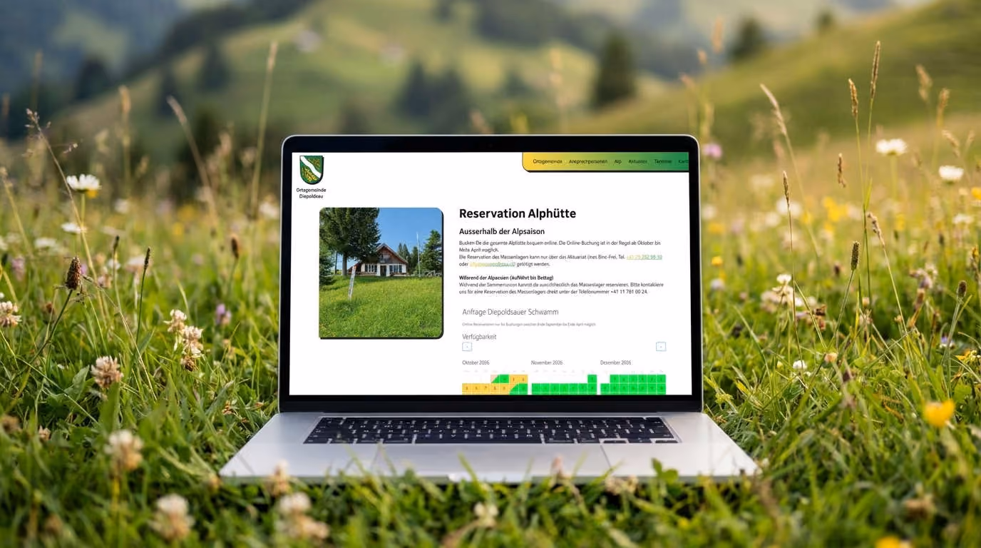 Laptop in einer Alpwiese zeigt die Reservationsseite für die Diepoldsauer Alphütte mit Verfügbarkeitskalender.