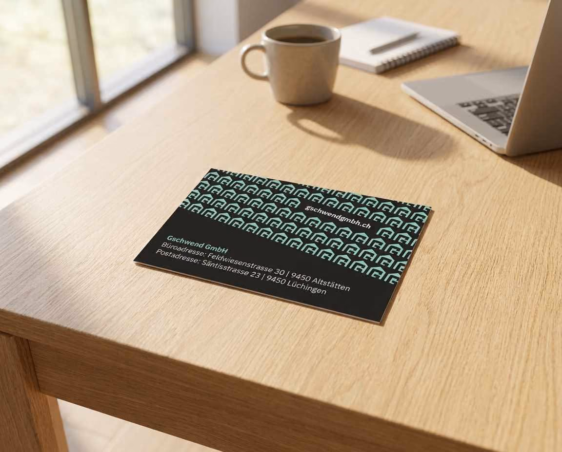 Neue Visitenkarte der Gschwend GmbH mit mintfarbenem Muster liegt auf einem Holztisch.