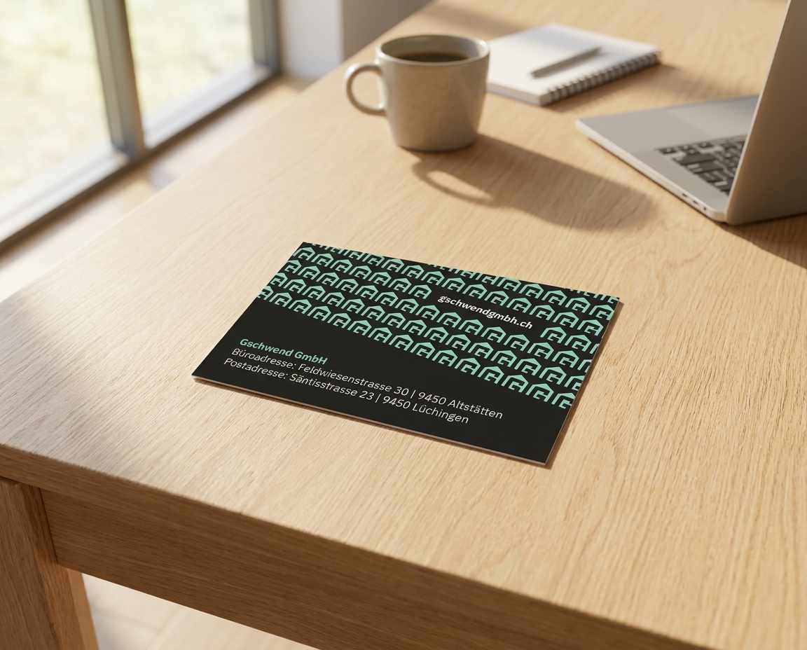 Neue Visitenkarte der Gschwend GmbH mit mintfarbenem Muster liegt auf einem Holztisch.
