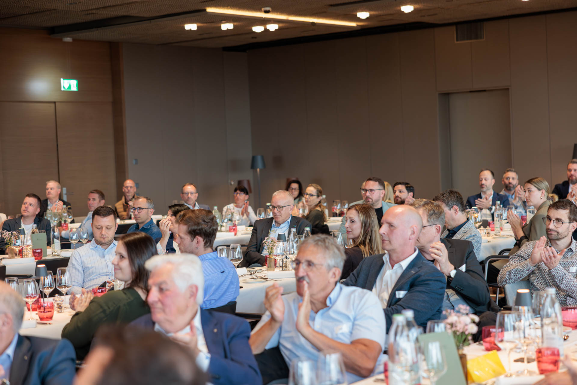 Applaudierende Teilnehmende an den gedeckten Tischen im Saal des Wolfsbergs in Ermatingen