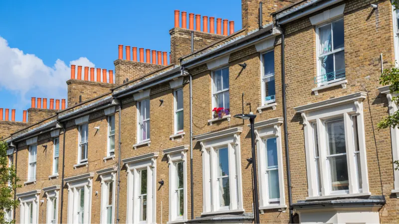 Victorian houses, with white sash windows, some with flowers on the window sills.