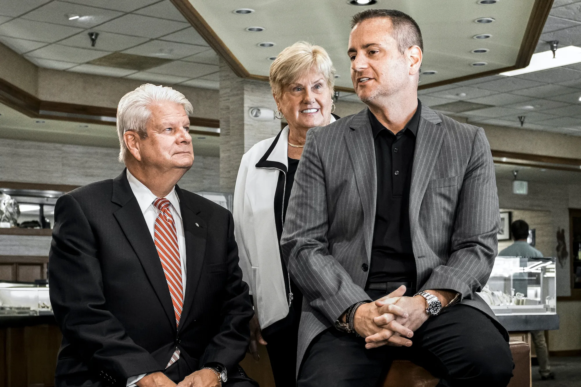 CEO John Carter sitting with former CEO John Wohlwend and his wife inside the Jack Lewis Jewelers store location
