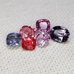 collection of loose colored gemstones on a white table