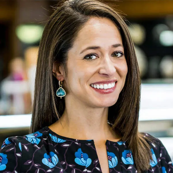 sales manager Missy smiling and wearing a pair of tear drop teal earrings