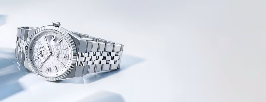 Centered in a clean, light-filled setting of sculpted shadows, the Rolex Land-Dweller 40 in white Rolesor showcases a fluted bezel, white honeycomb dial, and Flat Jubilee bracelet. Driven by the high-frequency Calibre 7135, it represents a new era of precision and craftsmanship. Jack Lewis Jewelers of Bloomington, Illinois, now at 3011 Galena Rd, is proud to be part of the worldwide network of Official Rolex Jewelers.