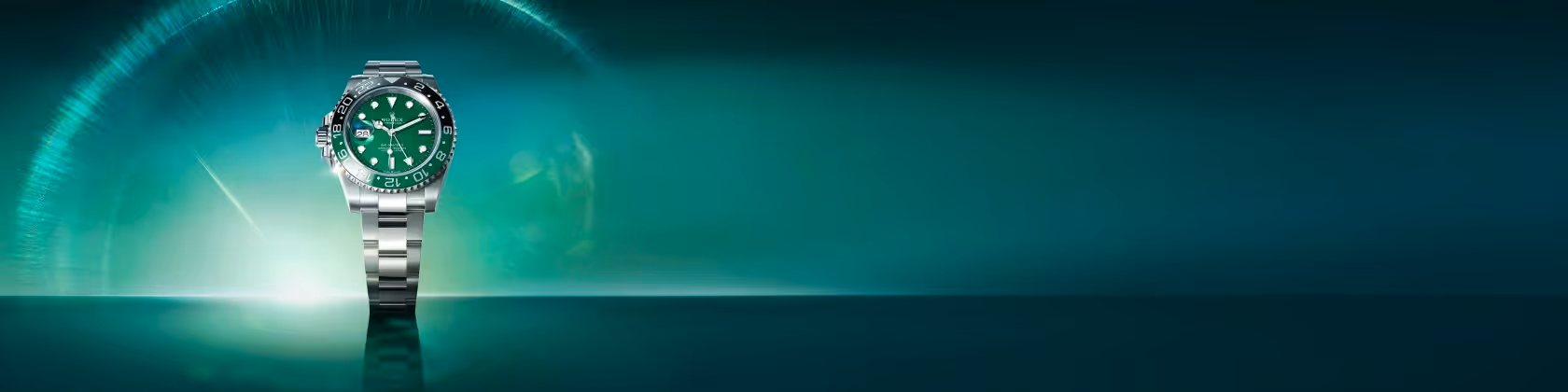 Positioned to the left against a radiant green gradient backdrop, the Rolex GMT-Master II in Oystersteel features a striking green dial and black Cerachrom bezel insert. Its robust 40 mm Oyster case, equipped with a bidirectional rotatable bezel and 24-hour graduated scale, embodies functionality and timeless design. Powered by the calibre 3285, a self-winding mechanical movement, this watch offers precision and dual time zone capability. Presented on an Oyster bracelet, the GMT-Master II is the traveler’s ultimate companion. Jack Lewis Jewelers of Bloomington, Illinois, now at 3011 Galena Rd, is proud to be part of the worldwide network of Official Rolex Jewelers.