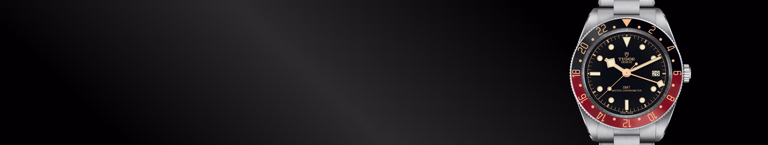 The TUDOR Black Bay 58 GMT, model M7939G1A0NRU-0001, features a stainless steel case with a burgundy and black 24-hour bezel, a black dial with luminous hour markers, and a stainless steel bracelet beneath a domed sapphire crystal. The watch appears on the right side of the image against a black textured background with subtle gold accents. Jack Lewis Jewelers, located at 3011 Galena Rd, Bloomington, Illinois, is proud to be part of the worldwide network of Official TUDOR Jewelers, authorized to sell and service TUDOR watches.