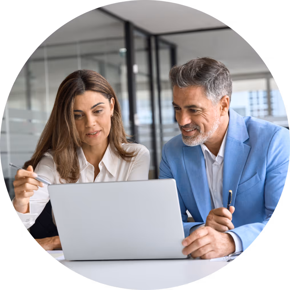Business professionals collaborating on a laptop in a modern office