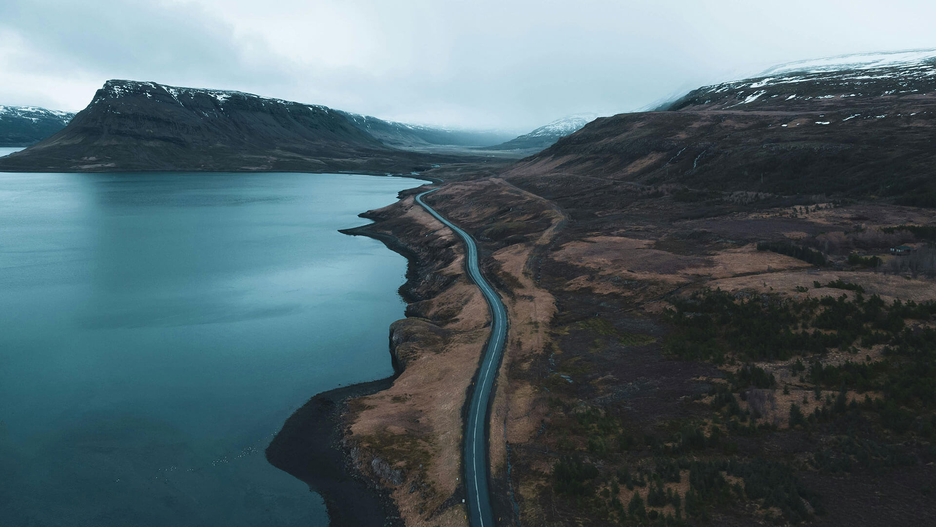 Road winding hill with the sea on the left.