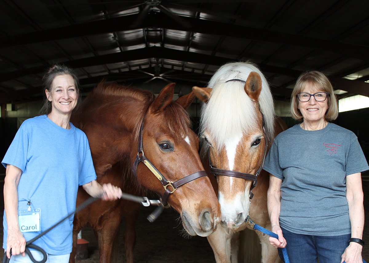 Two volunteers with two Equine-Assisted Therapy, Inc. therapy horses.