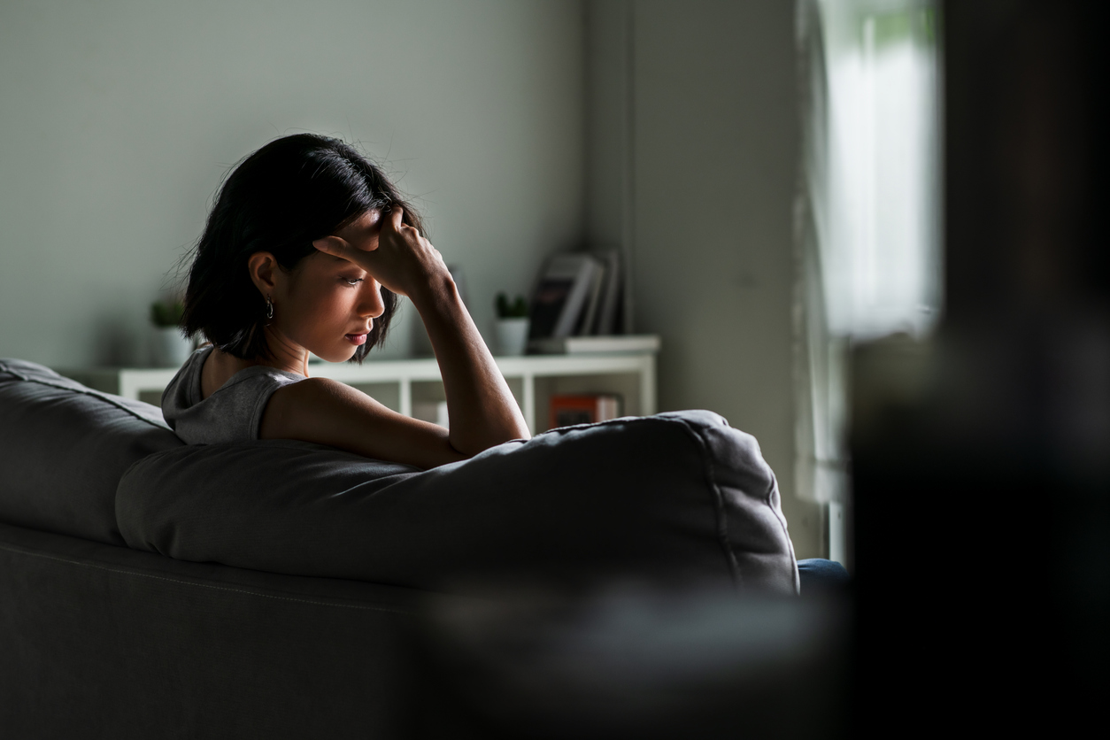 depressed woman sitting on a couch